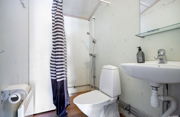 Un baño con ducha, inodoro y lavamanos.
