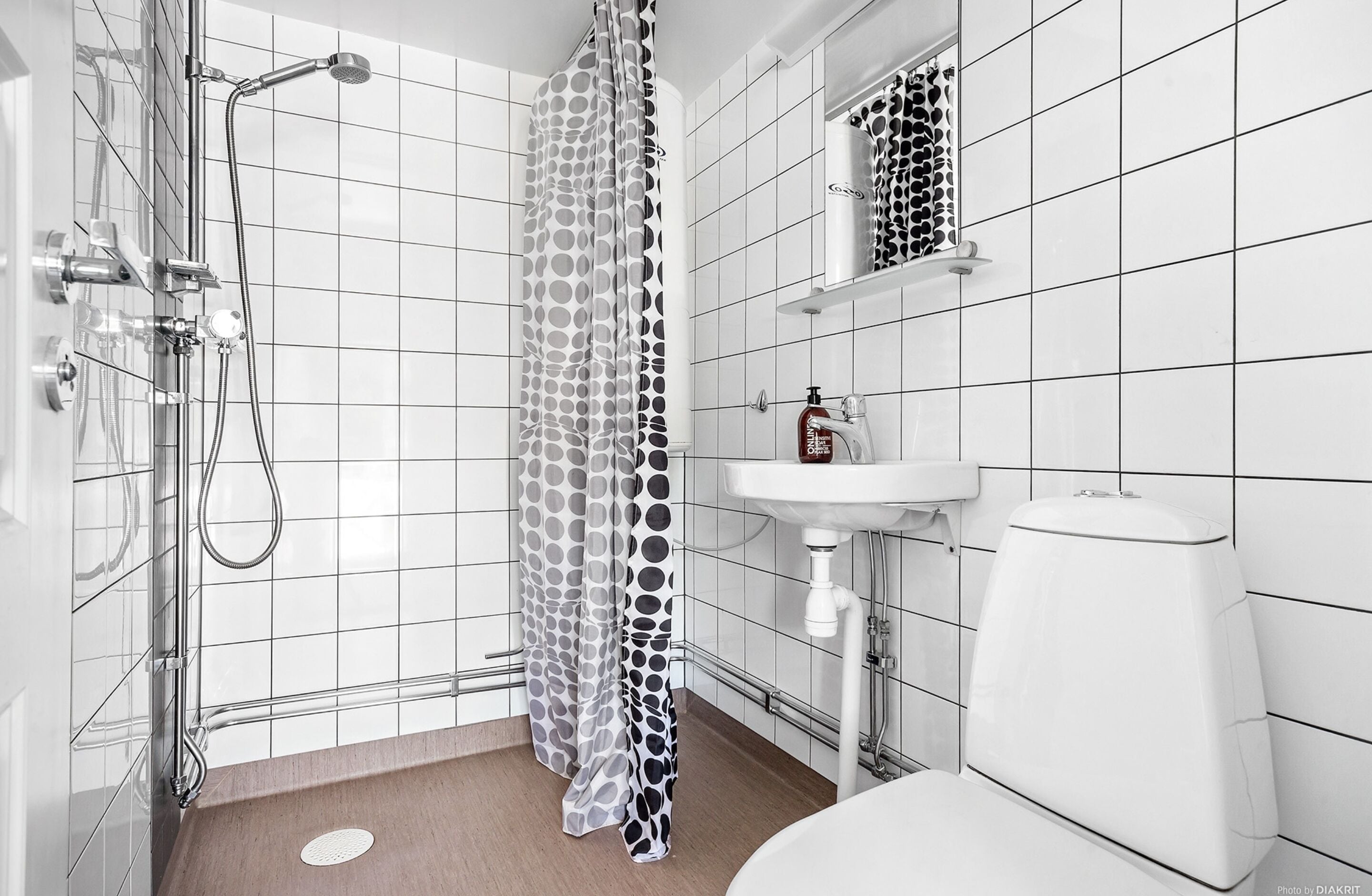 A modern bathroom with a shower, toilet, and sink.