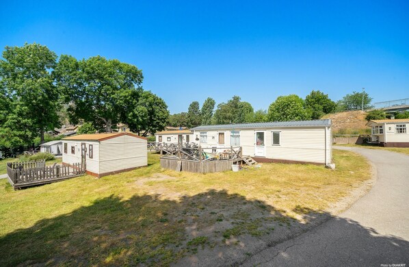 A mobile home park with several single-story homes, a fenced playground, and a paved road. - First Camp Nickstabadet Nynäshamn (Nynashamn)