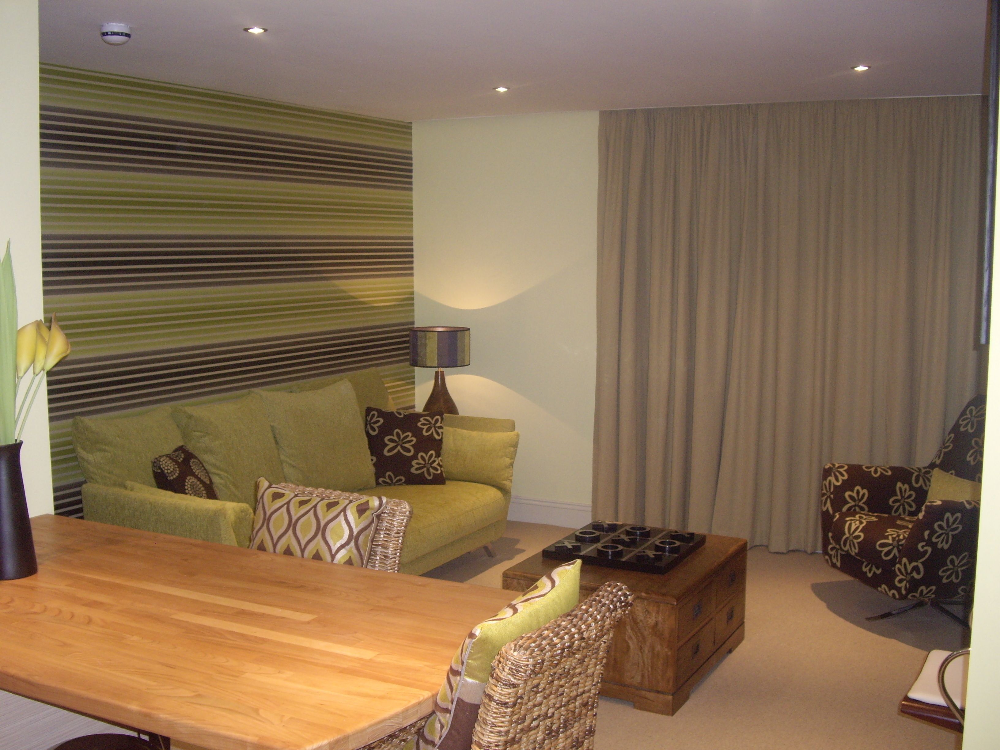 A living room with a sofa, a wooden coffee table, and a lamp.