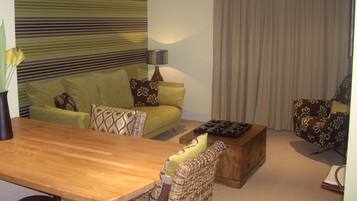 A living room with a sofa, a wooden coffee table, and a lamp.
