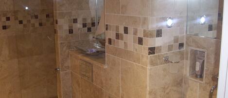 A bathroom with a toilet, sink, and shower area.