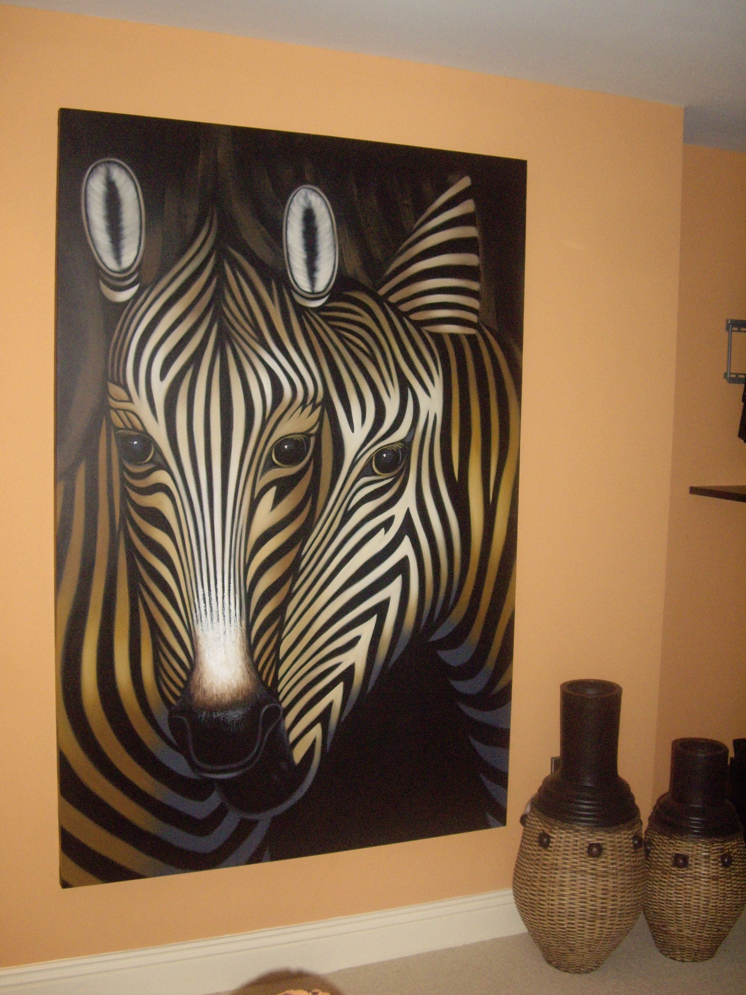 Ein Zebra-Wandgemälde, zwei Korbvasi und eine weiße Fußleiste.
