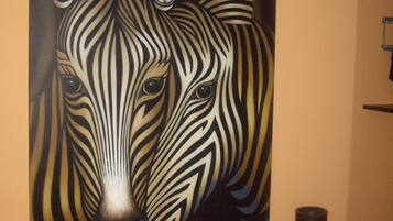 Ein Zebra-Wandgemälde, zwei Korbvasi und eine weiße Fußleiste.