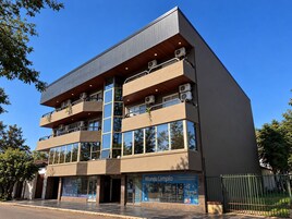 Un edificio moderno con varios balcones, amplias ventanas y un letrero que dice 'Mundo Limpio'.