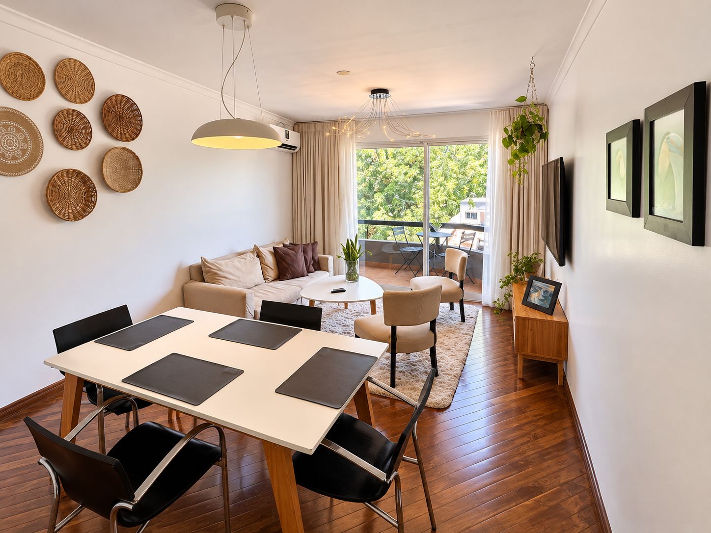 A modern living room with a dining area, a sofa, a coffee table, and a balcony with a view.