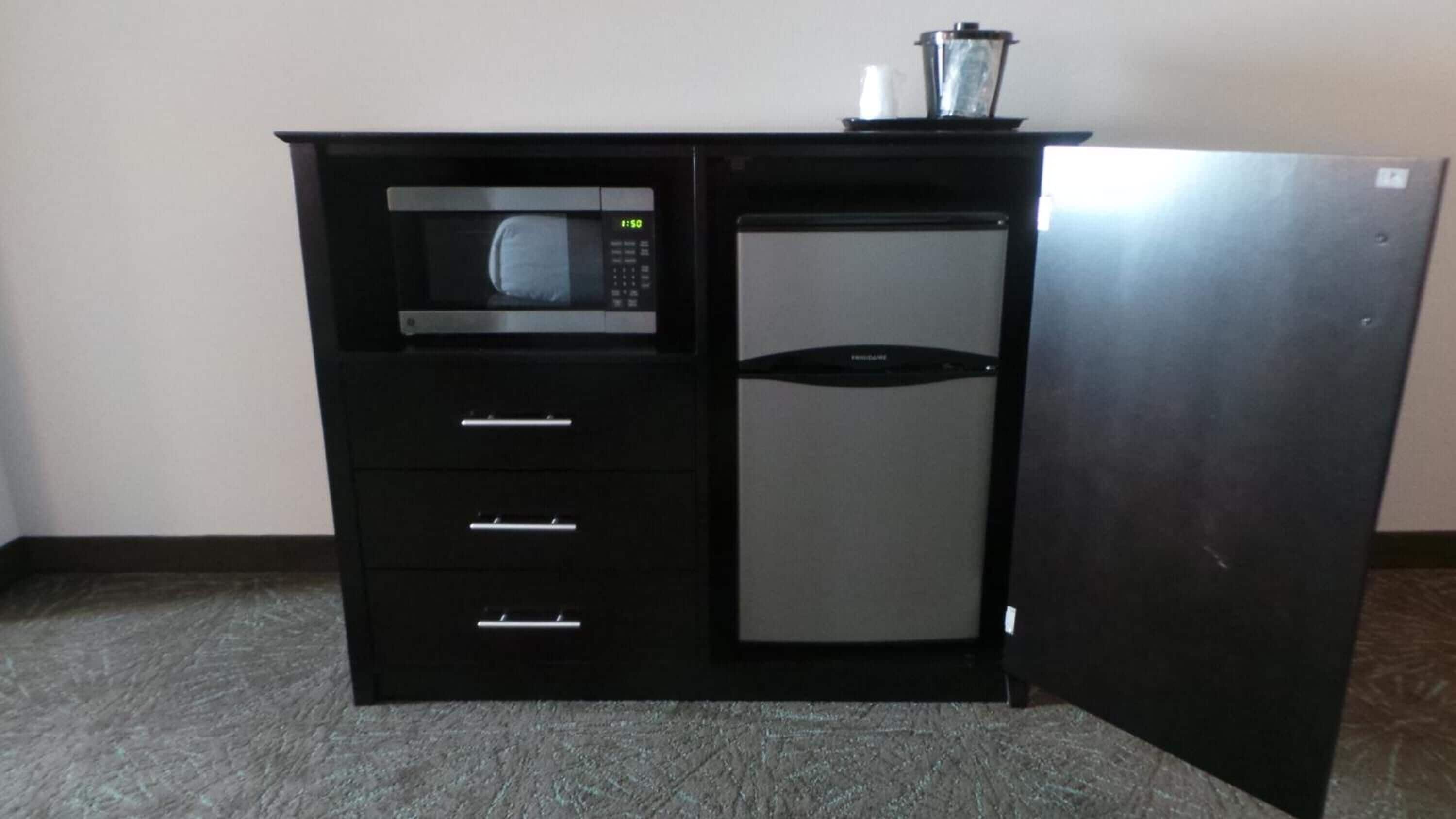 Una kitchenette con microondas, refrigerador y licuadora.