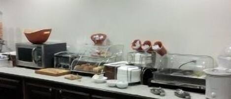 A buffet setup with various food items and appliances.