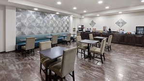 A modern hotel lobby with a seating area, a bar, and a coffee station.