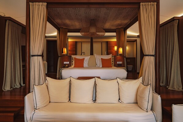 Una habitación de hotel con una cama grande, un sofá y cortinas.