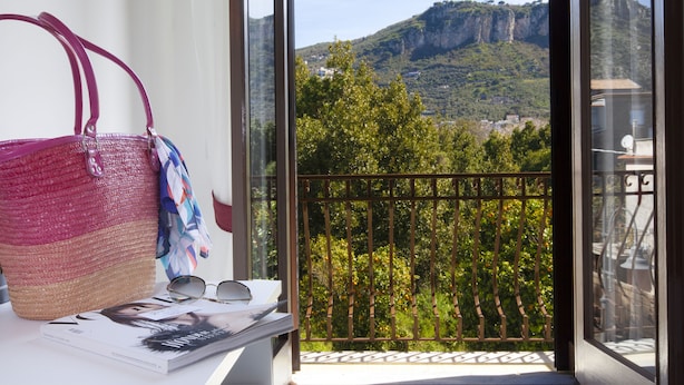 Un balcon avec vue sur une montagne et la verdure.