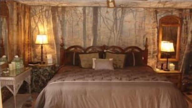 A bedroom with a bed, nightstands, and lamps.