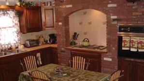 A kitchen with a dining table, chairs, a stove, and a refrigerator.