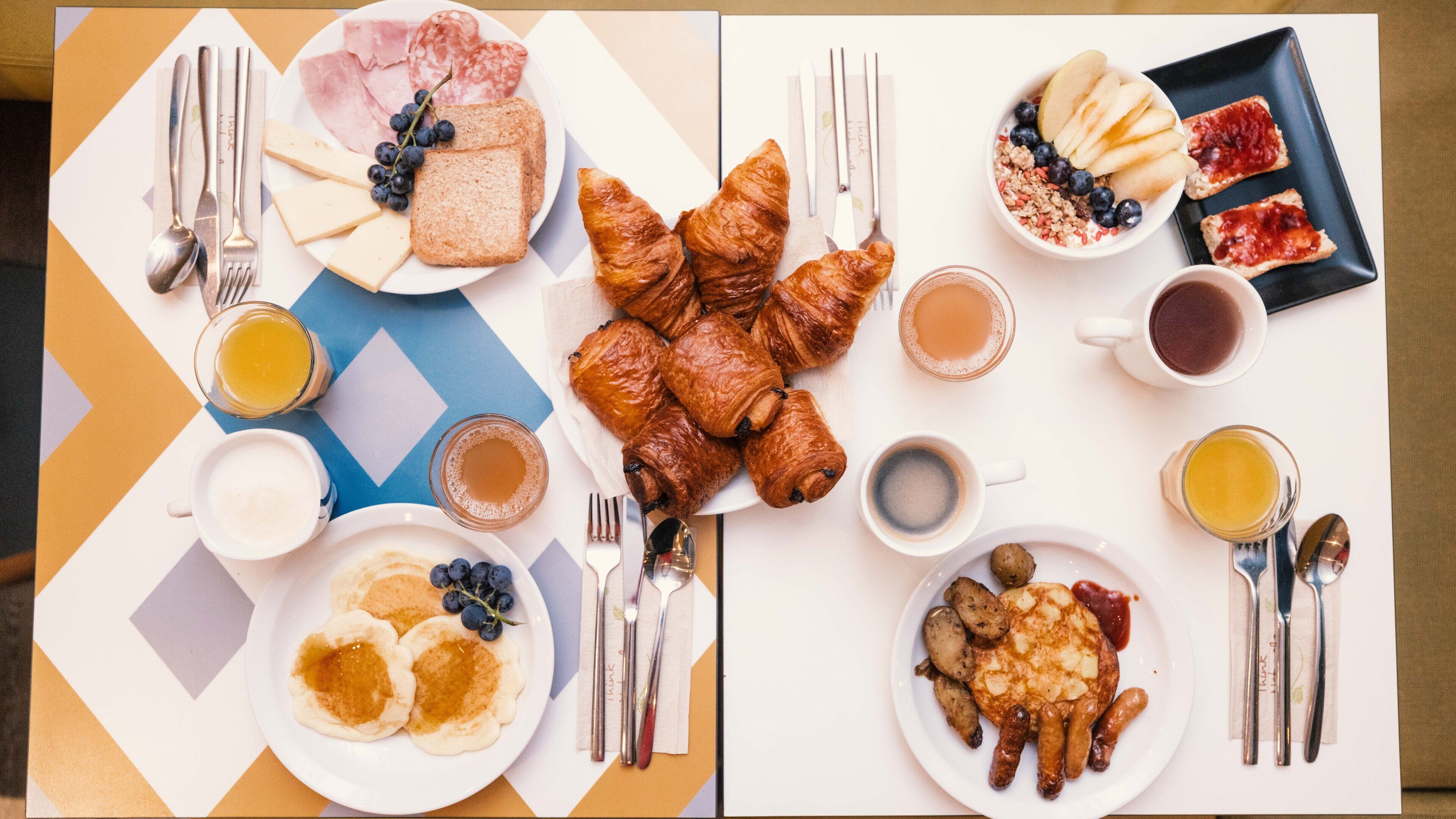 A breakfast buffet with various food items and utensils.