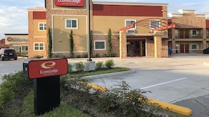 Een hotel met een opvallend bord voor EconoLodge Inn & Suites, met een gevel van baksteen en een overdekte ingang.
