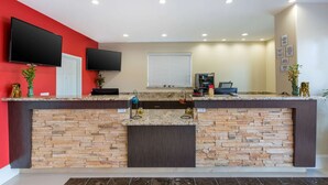 A modern kitchen with a stone backsplash, granite countertops, and a built-in TV. - Econo Lodge Inn & Suites Houston Willowbrook (Houston)