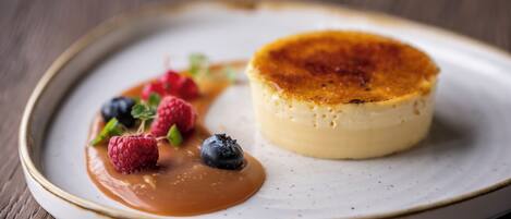 A dessert plate with a caramel sauce and berries.