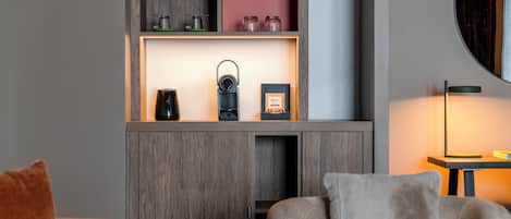 A modern living room with a wooden cabinet, a coffee maker, and a framed certificate.