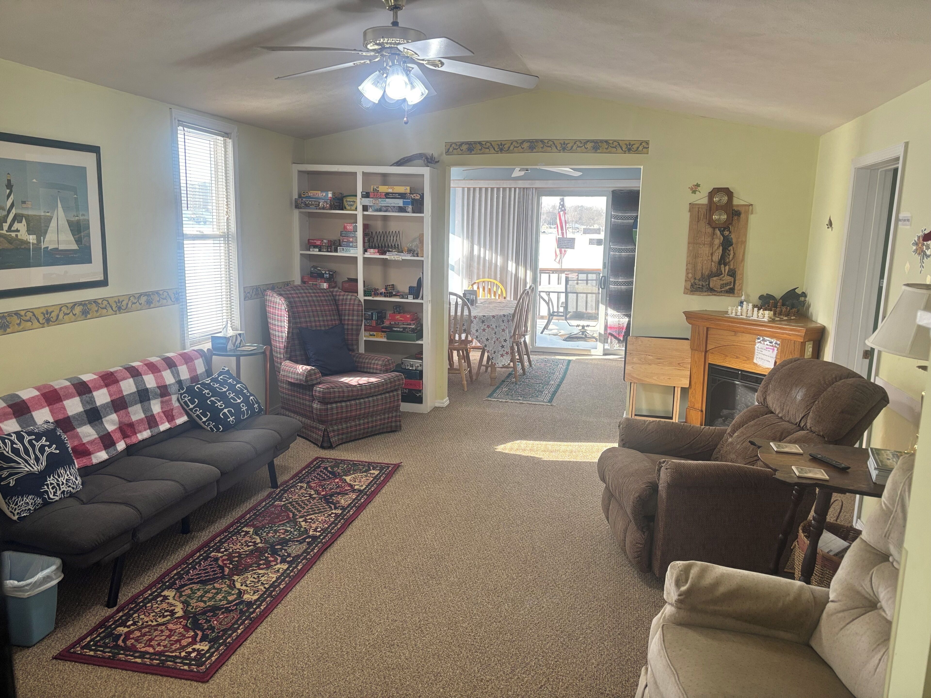 A living room with a sofa, armchair, and a bookshelf.