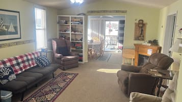 A living room with a sofa, armchair, and a bookshelf.