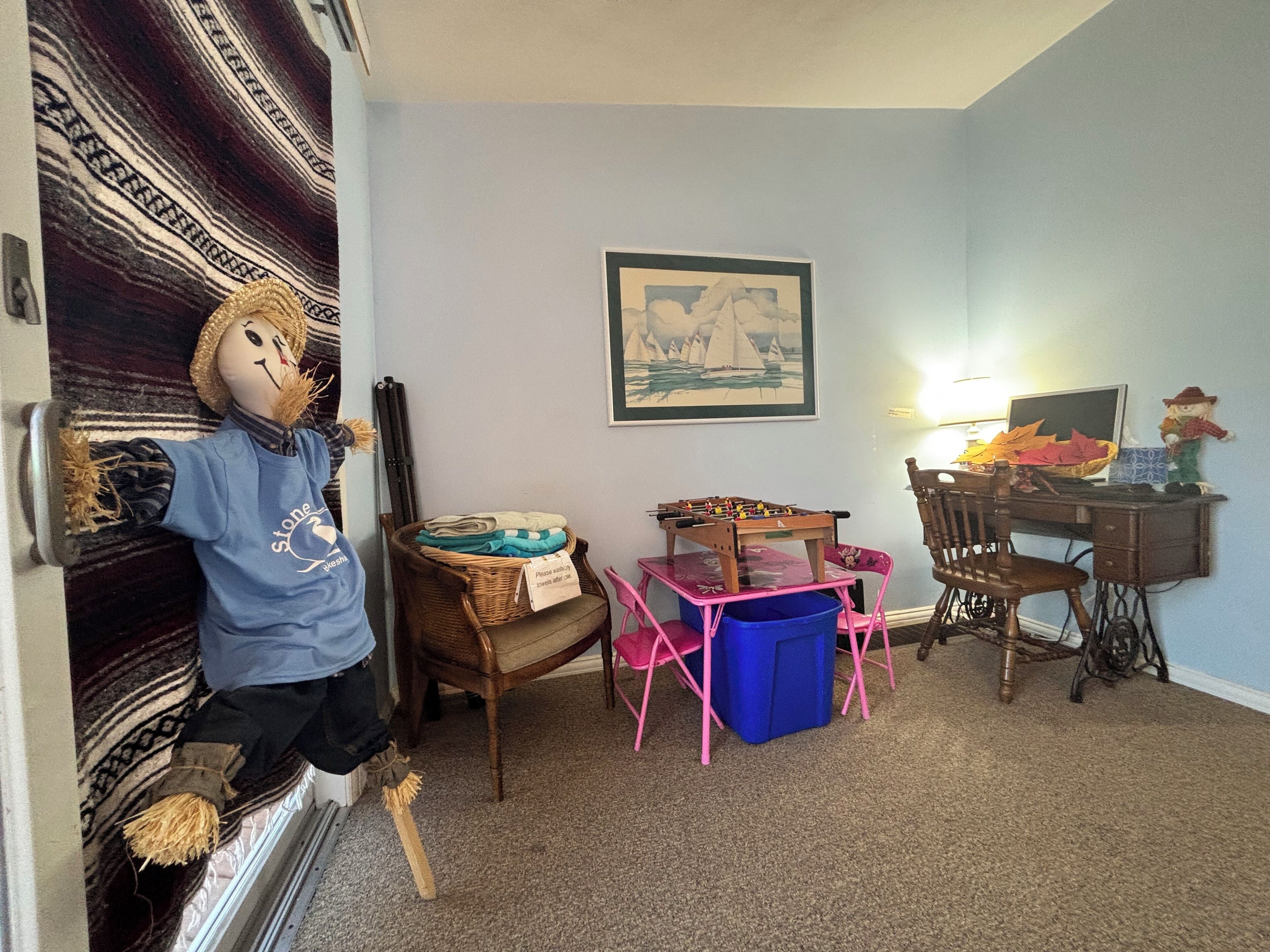 Ein gemütliches Zimmer mit Schreibtisch, Stuhl und einer Dekofigur.