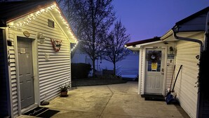 Et hus med garageport, en lille veranda med en potteplante og en postkasse.