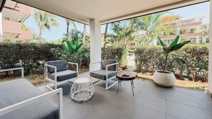 A modern outdoor patio with seating, a round table, and potted plants. - Choisy Les Bains with LOV (Mont Choisy)