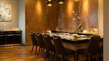 A bar area with a bar counter, chairs, and a wall with a textured finish.