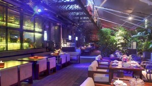 An indoor restaurant with wooden tables and chairs, large windows, and indoor plants. - Fuzhou Boerya Wuyi Hotel (Fuzhou)