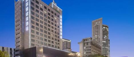 A multi-story hotel with a modern facade, large windows, and a prominent entrance.