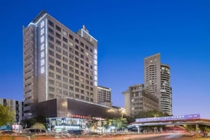 Un hotel de varios pisos con una fachada moderna, ventanas amplias y una entrada destacada.