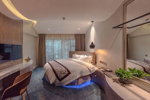 A hotel room with a bed, desk, chair, and a large mirror. - Fuzhou Boerya Wuyi Hotel (Fuzhou)