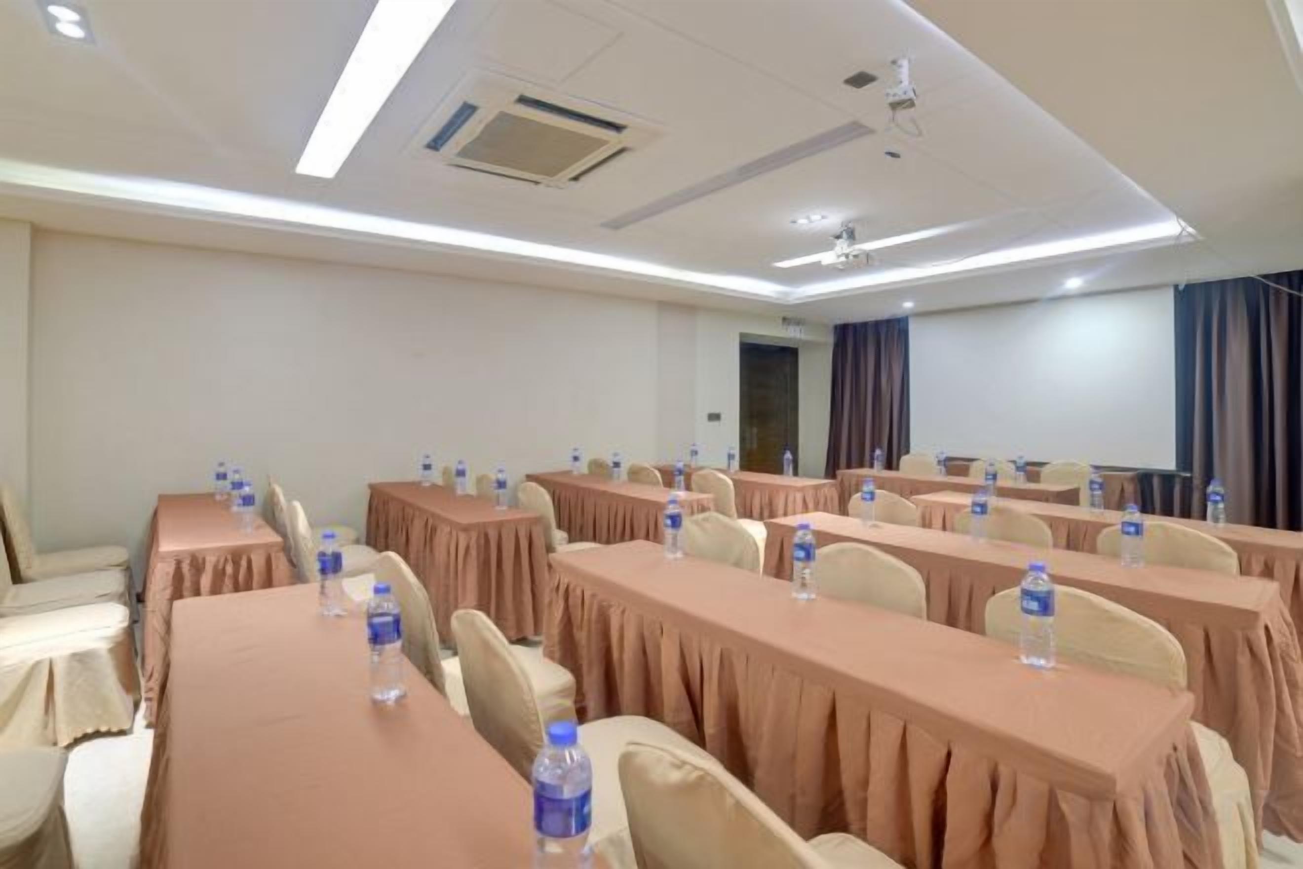 A conference room with long tables, chairs, and water bottles.