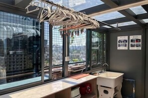 Un baño moderno con un ventanal grande, un lavamanos y una zona de ducha.