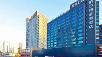 Un hotel de varios pisos con un letrero llamativo, grandes ventanales y un diseño arquitectónico moderno.