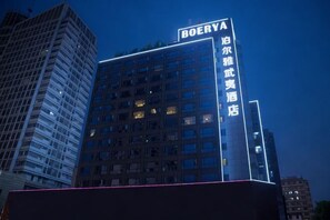 Un hotel de gran altura con señalización iluminada, varios pisos y un diseño arquitectónico moderno.