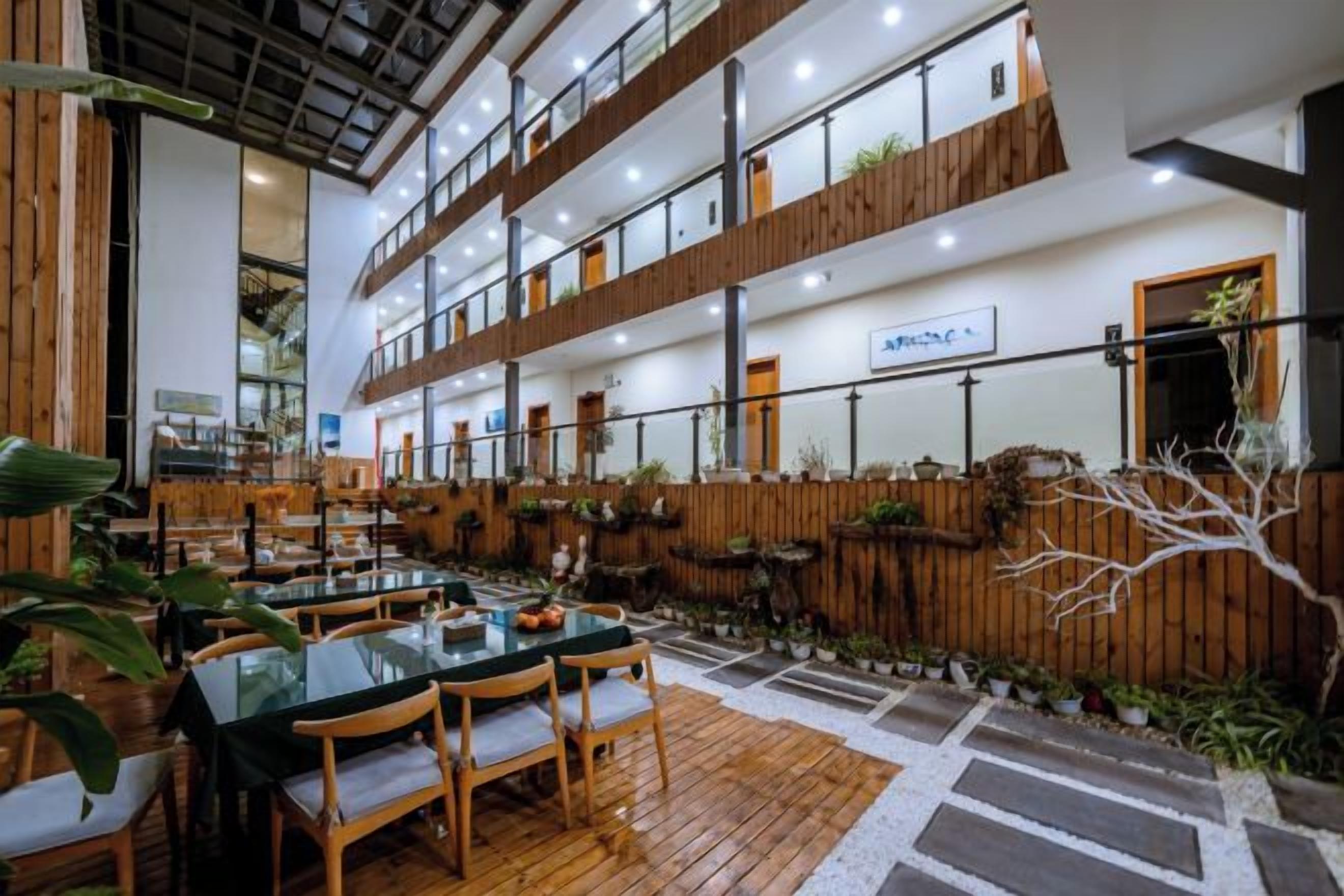 A multi-level restaurant with outdoor seating, wooden flooring, and a view of the sky.