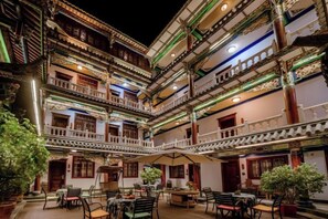 A multi-story building with balconies, outdoor seating, and potted plants. - Jiangnanju Boutique Hotel (Dali City)