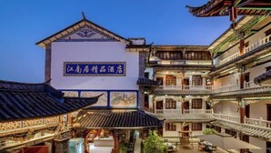 Une cour traditionnelle avec une enseigne indiquant « Jiangnan Home Specialty Hotel ».