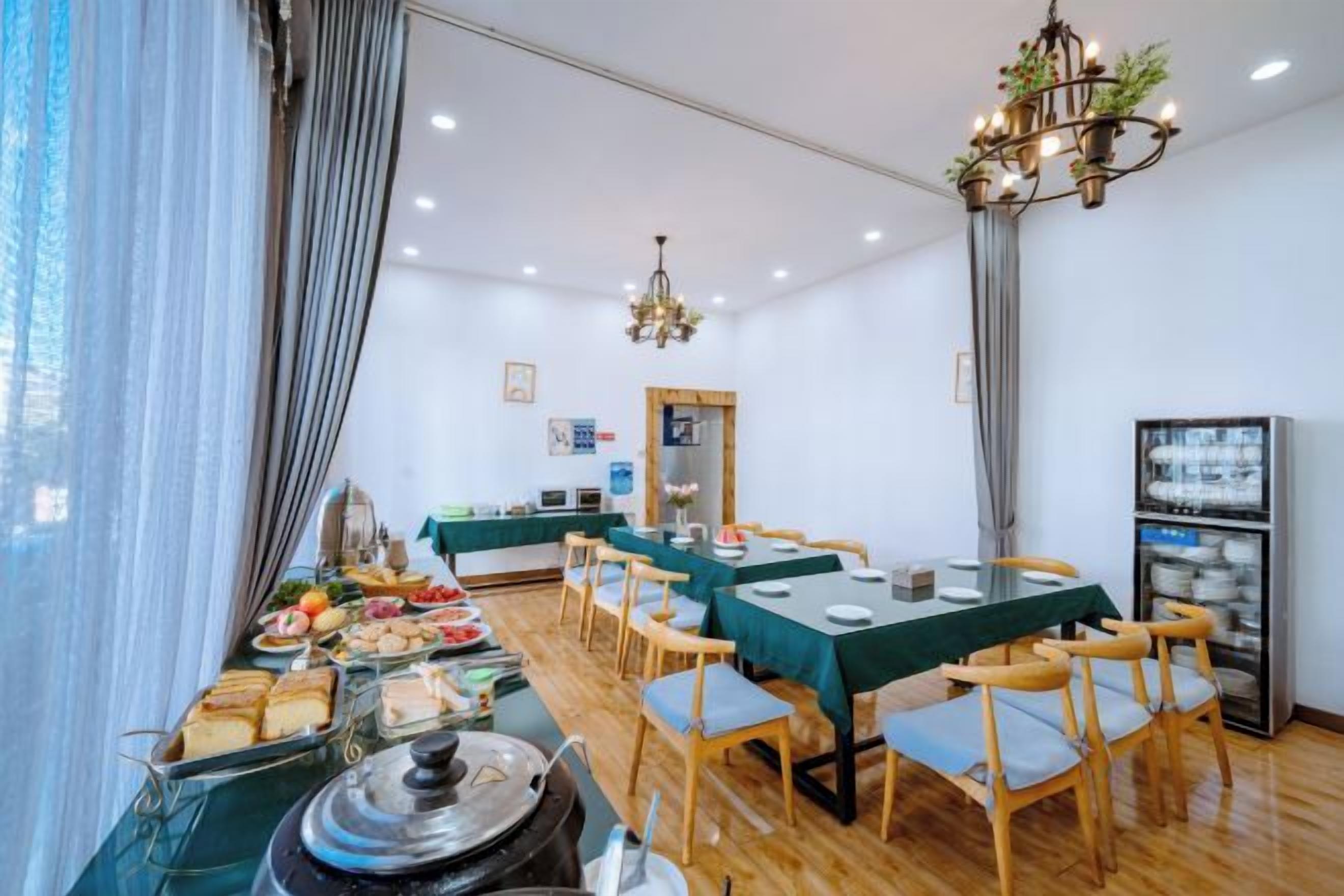 A dining area with tables, chairs, and a buffet with various food items.