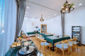 Un comedor con mesas, sillas y un bufé con diferentes opciones de comida.