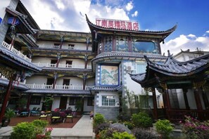 A traditional Chinese building with multiple balconies and a sign in Chinese characters. - Jiangnanju Boutique Hotel (Dali City)