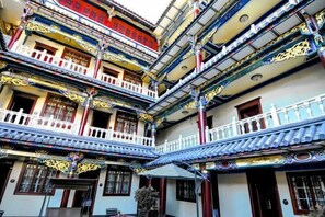 Un edificio de varios pisos con elementos arquitectónicos tradicionales, como balcones ornamentados y decoraciones elaboradas en el techo.