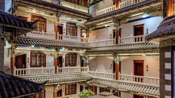 Un bâtiment traditionnel à plusieurs étages, doté de balcons décoratifs et de toits couverts de tuiles.