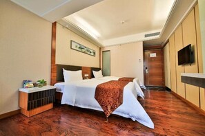 A hotel room with a bed, bedside table, and a television on the wall. - Hong Yang Hotel (Shenzhen)