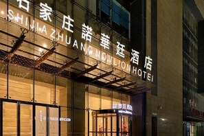 A hotel with a prominent sign in a foreign language, large windows, and a visible entrance. - Novlion Hotel (Shijiazhuang)