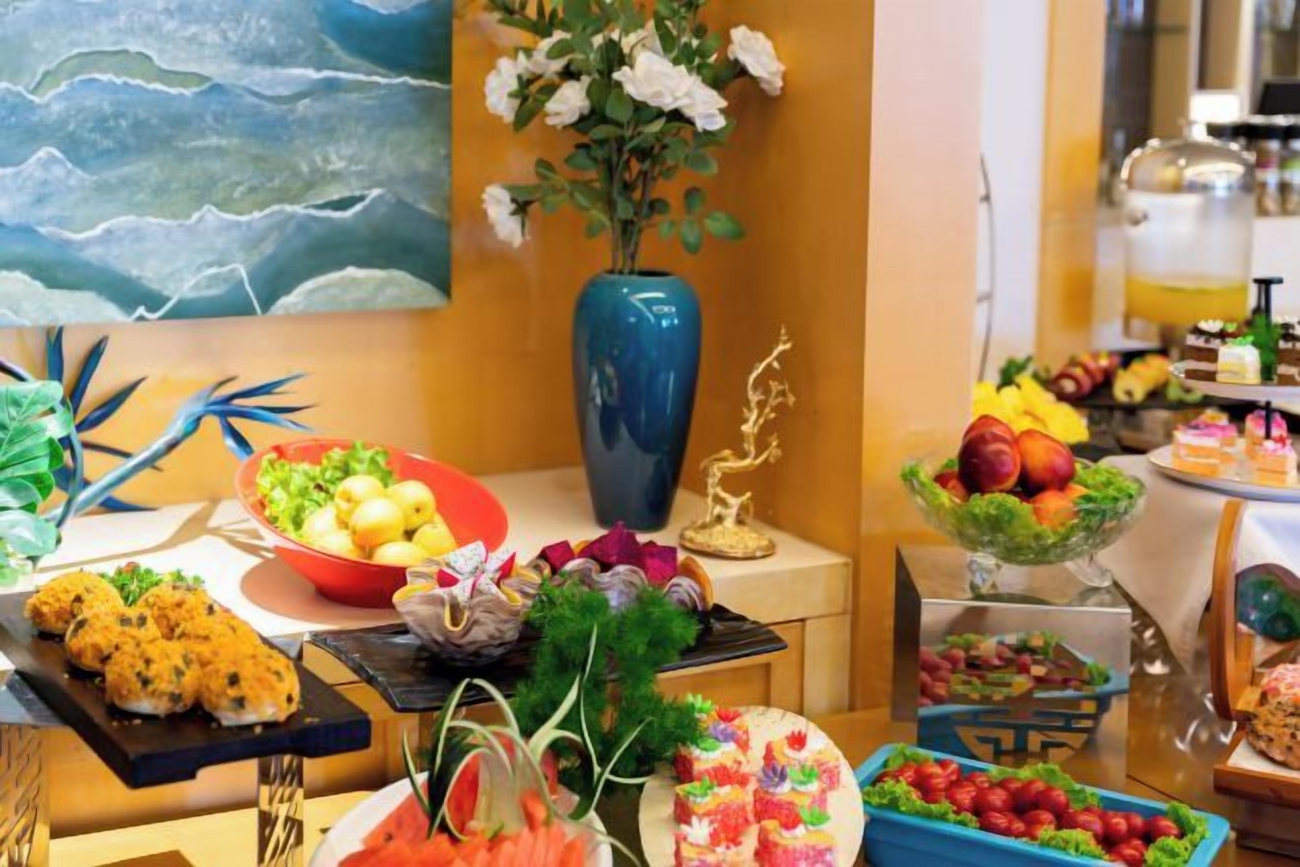 A buffet with various food items and a decorative vase.