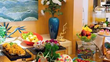 A buffet with various food items and a decorative vase.