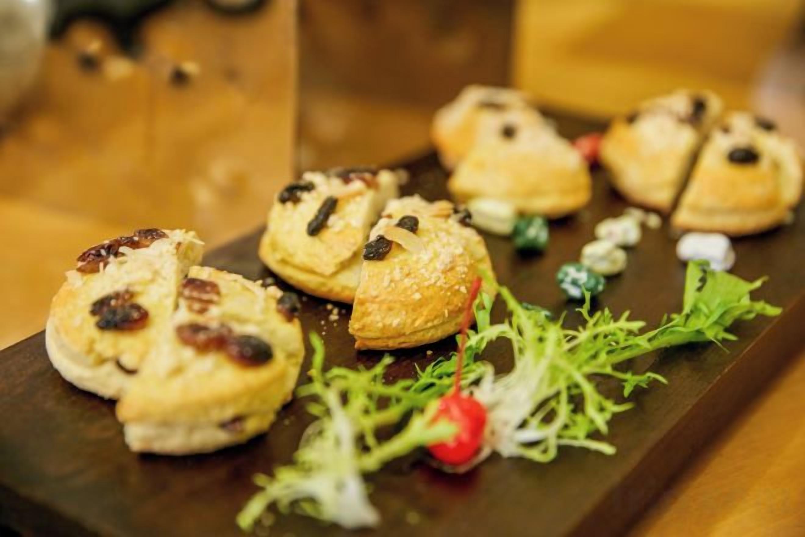 A variety of pastries on a wooden board with some greenery.