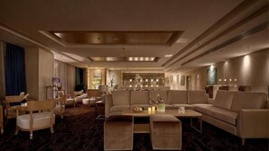 A hotel lobby with a sofa, chairs, a coffee table, and a bar area. - Novlion Hotel (Shijiazhuang)